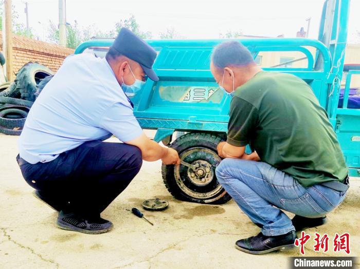 賽旦與民警共同維修三輪摩托車?！∫懒窘?攝