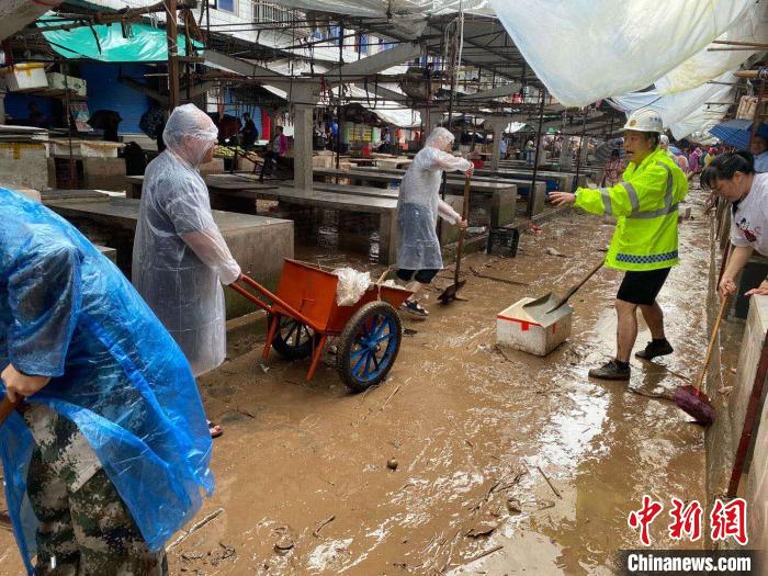 圖為7月26日，暴雨引發(fā)的洪水過境后，重慶萬州區(qū)分水鎮(zhèn)政府干部職工及志愿者清掃淤泥和垃圾?！　≈貞c萬州區(qū)委宣傳部供圖 攝